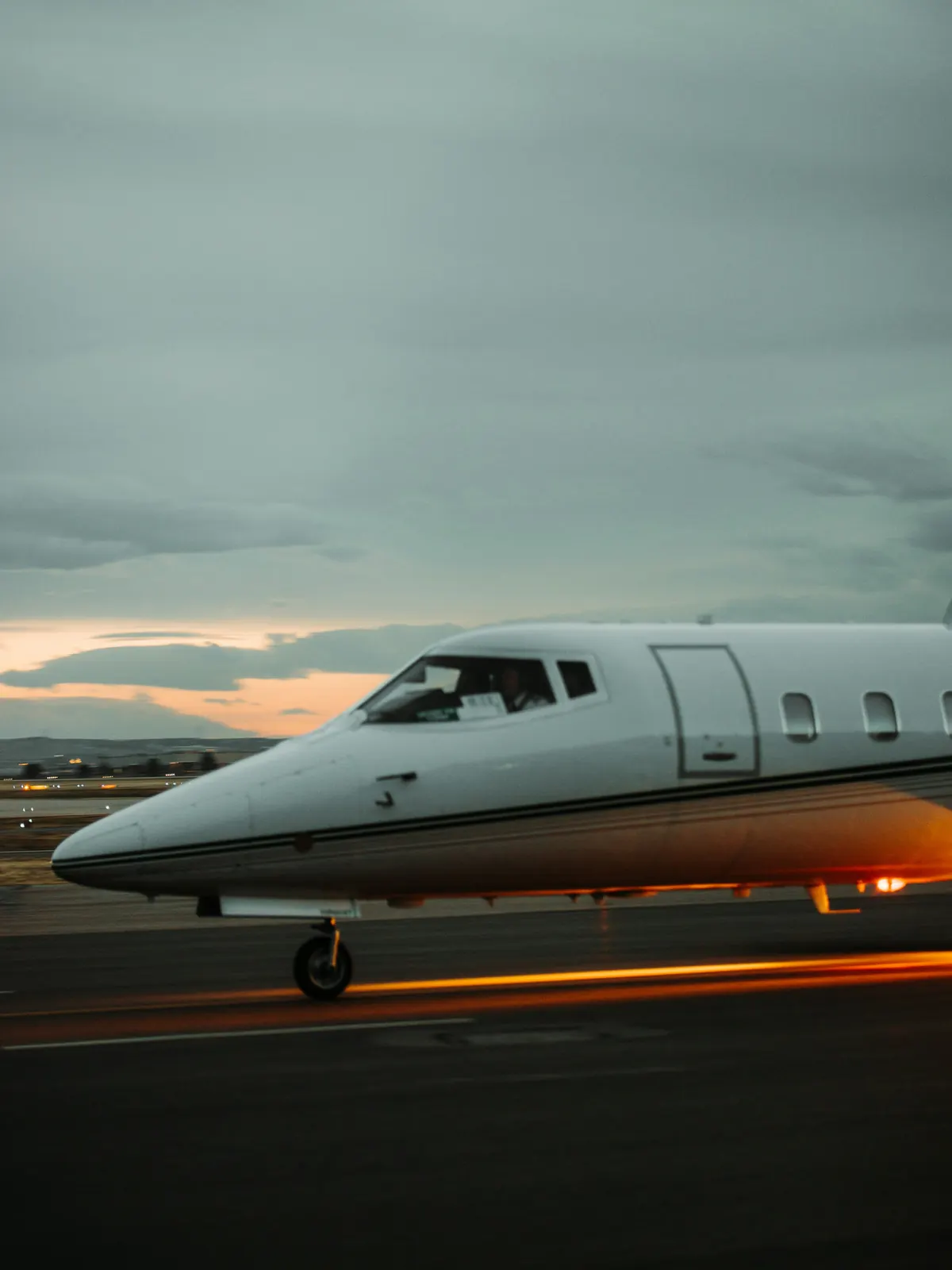 Light jet taxiing at dusk with its lights on